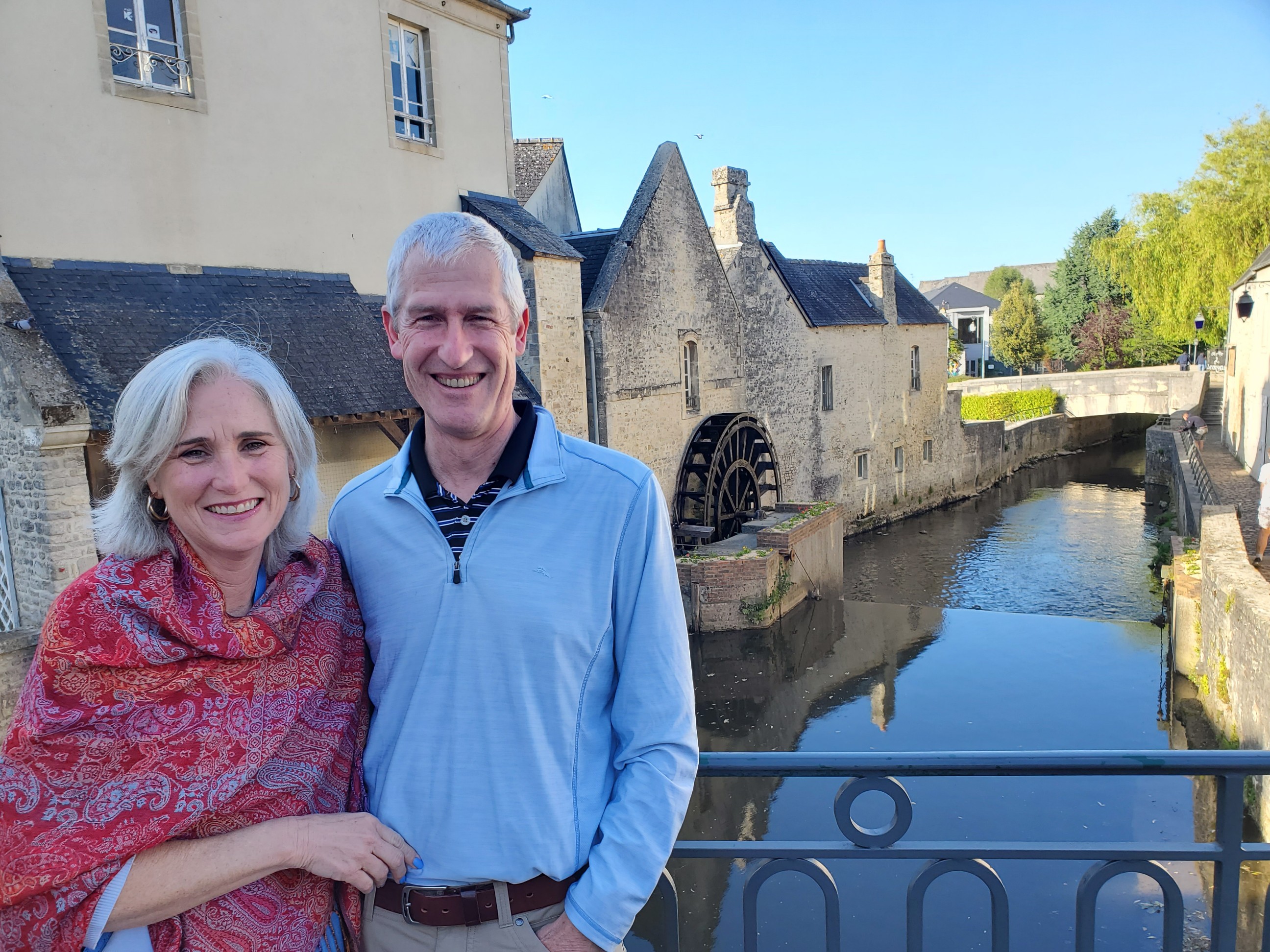 Melinda Carr with her husband next to a river running through a french town